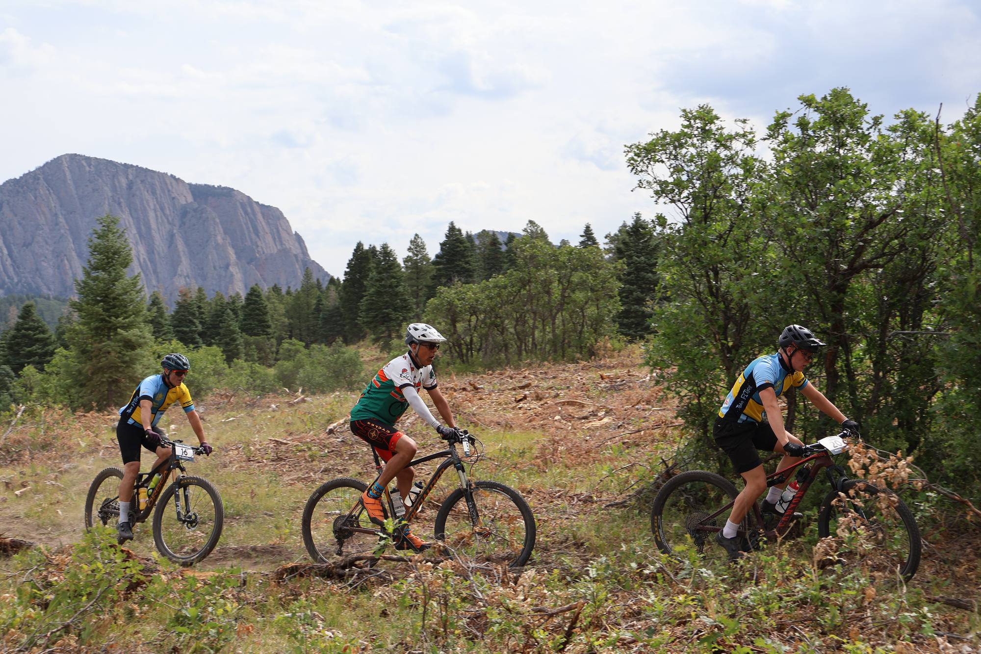 Riders crossing a meadow below the Brazos cliffs